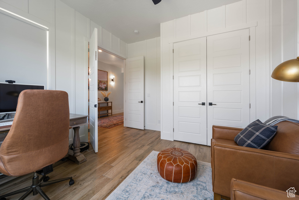 Office space with wood finished floors and a decorative wall