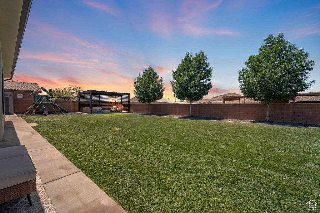 Yard at dusk featuring a playground