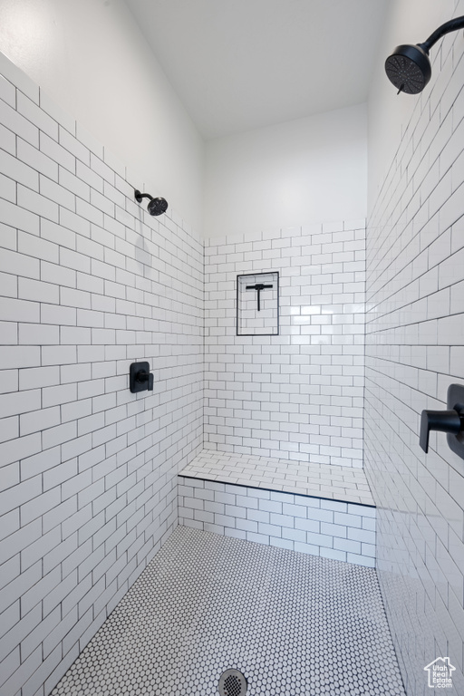 Full bathroom featuring a tile shower and tile patterned flooring