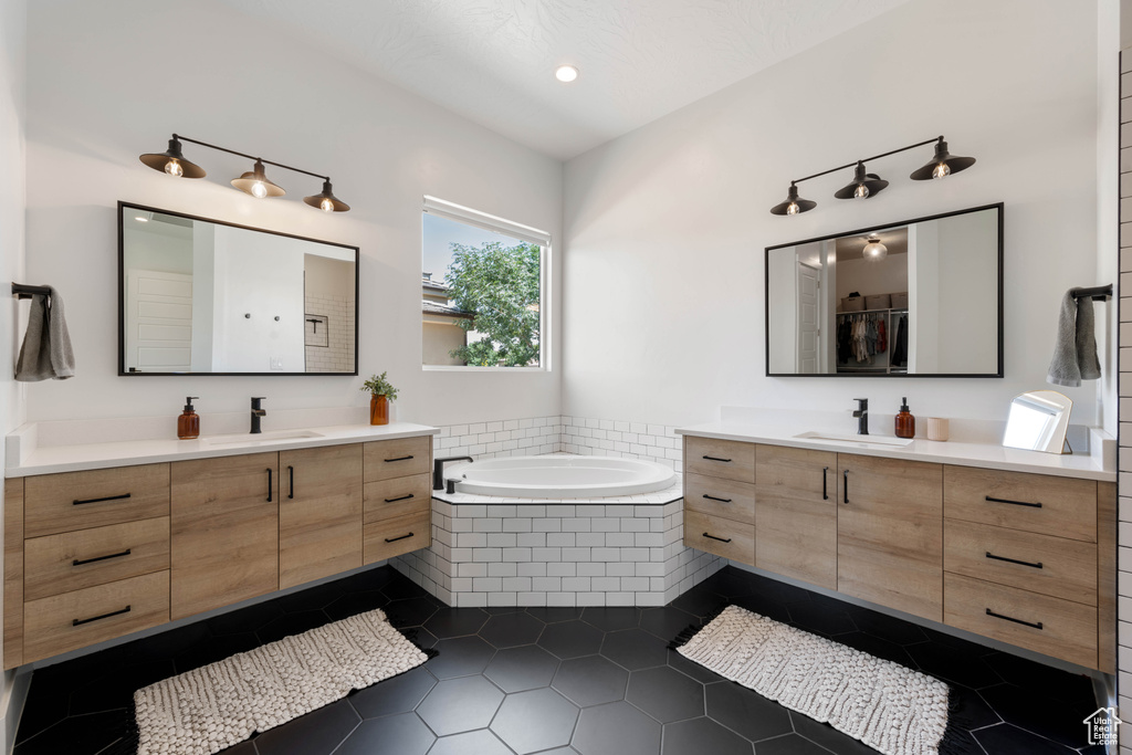 Full bath featuring two vanities, a garden tub, tile patterned floors, and recessed lighting