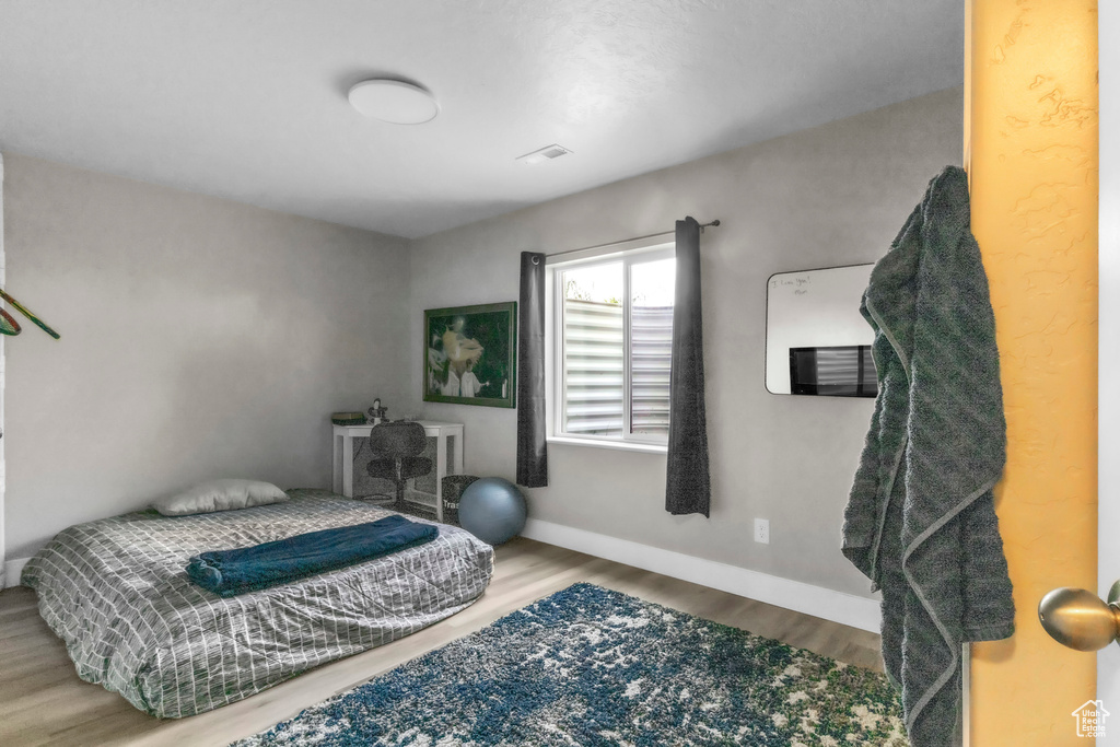 Bedroom with wood finished floors and baseboards