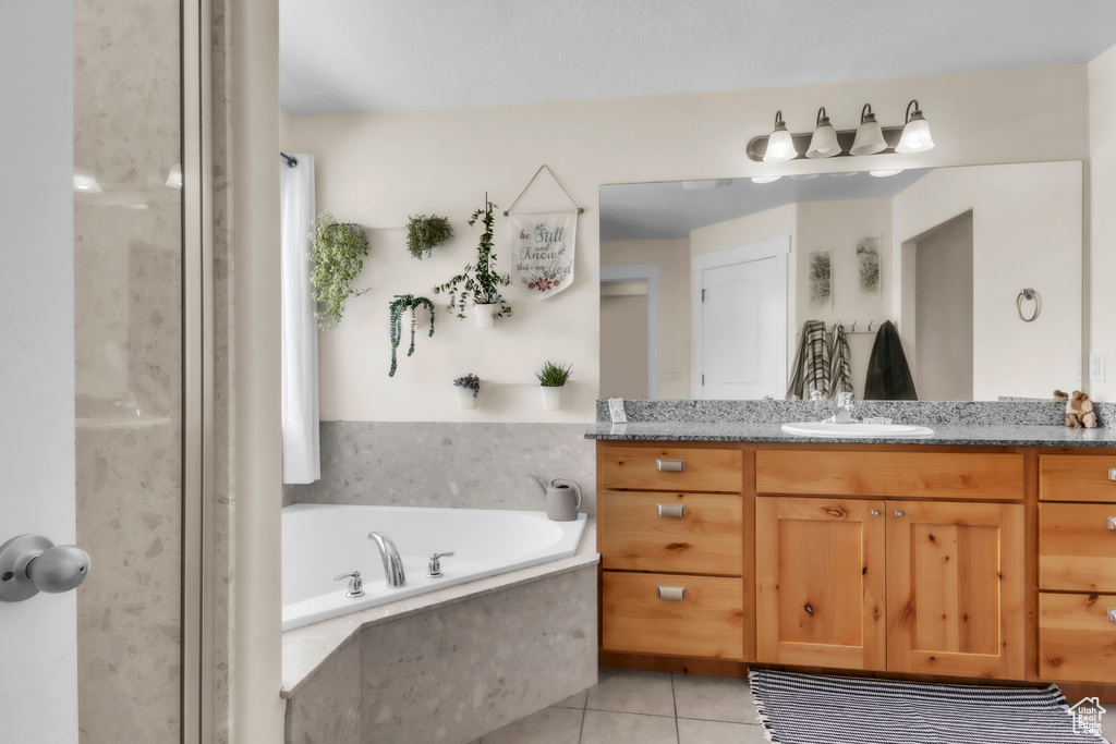 Bathroom with vanity, a bath, and tile patterned floors