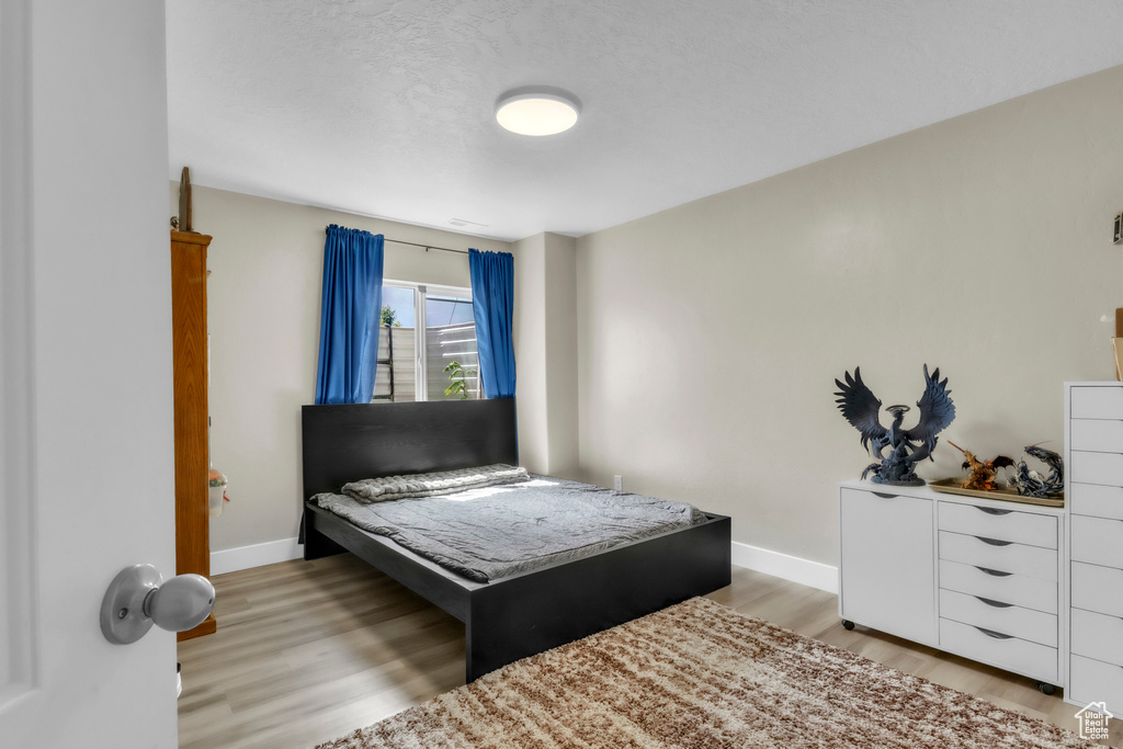 Bedroom featuring light wood finished floors and baseboards