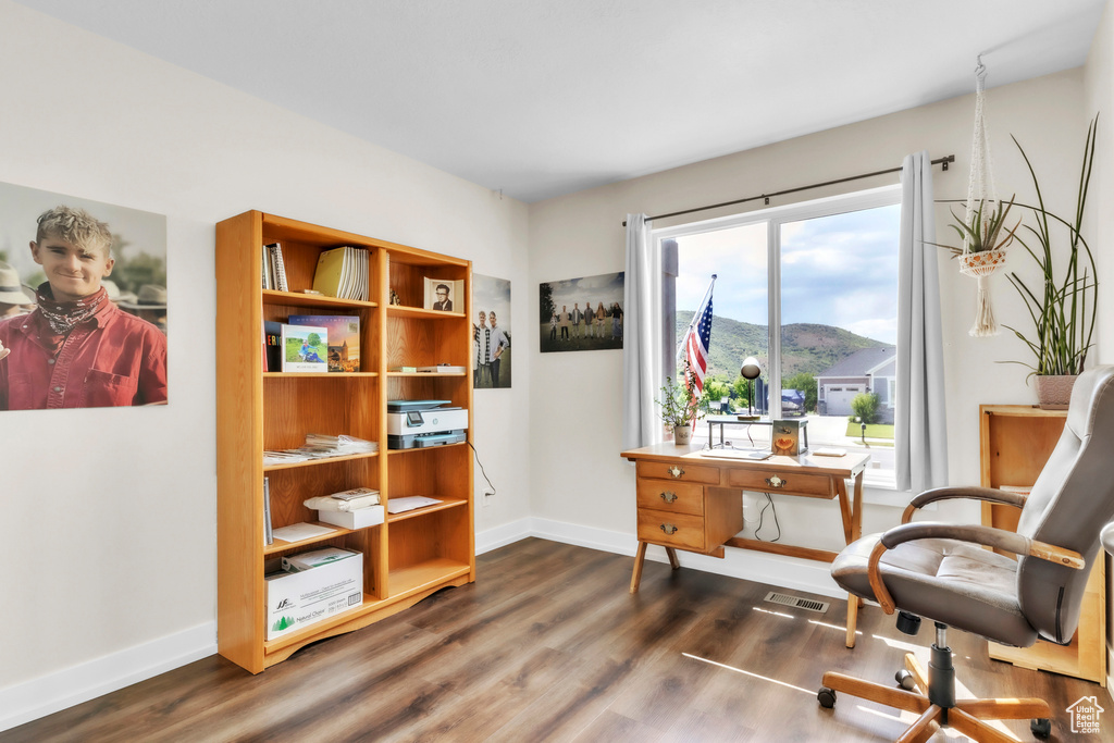 Sitting room featuring baseboards, dark wood-style flooring, an office area, and a mountain view