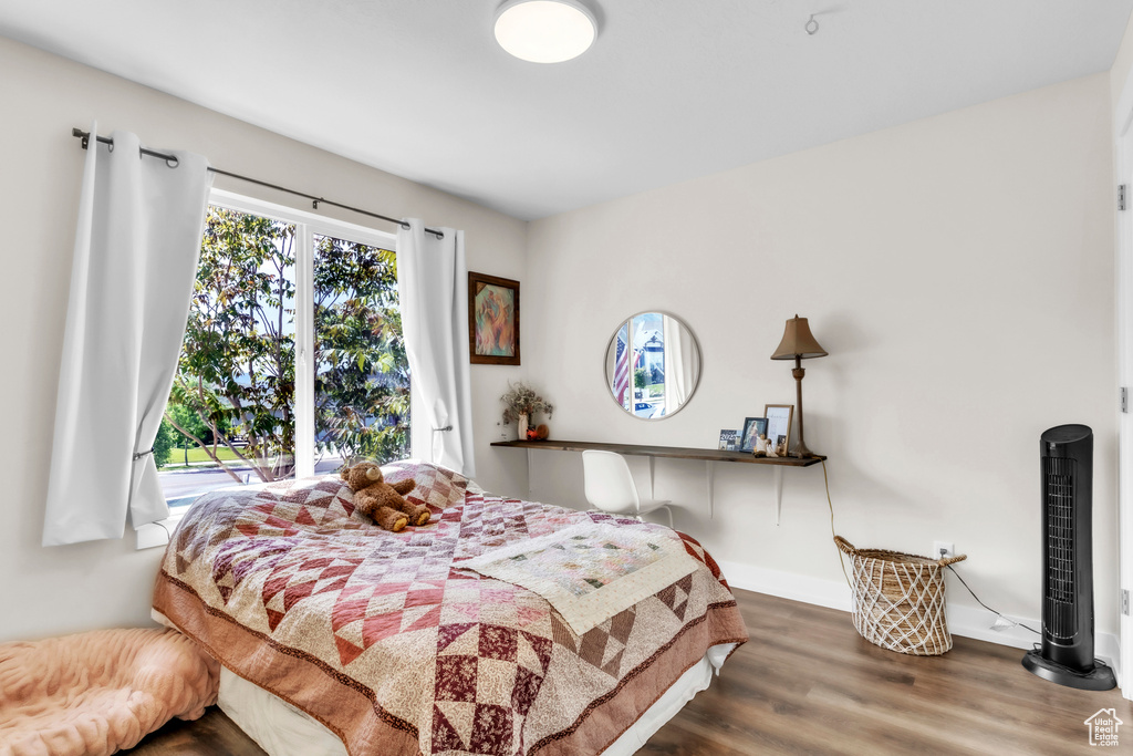 Bedroom with wood finished floors and baseboards