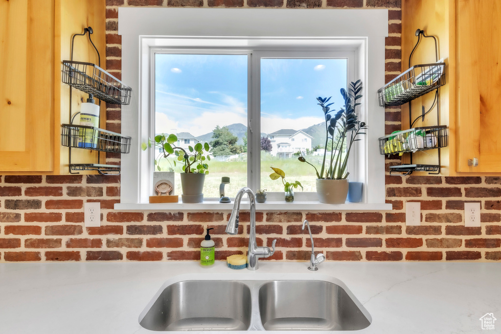 Kitchen view of a sink, decorative backsplash, and light countertops