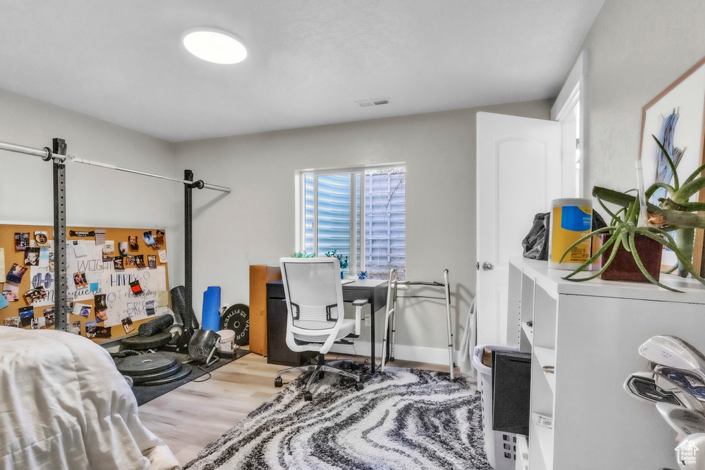 Bedroom with wood finished floors and multiple windows
