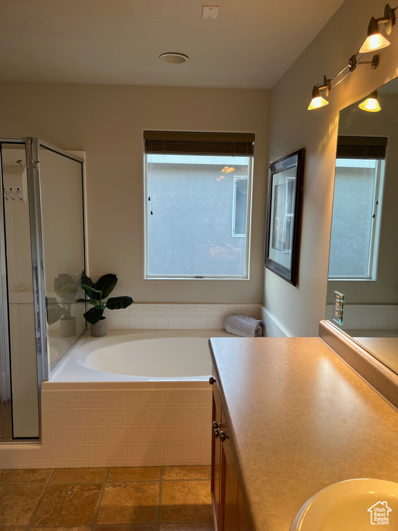 Full bath featuring a bath, vanity, and a stall shower