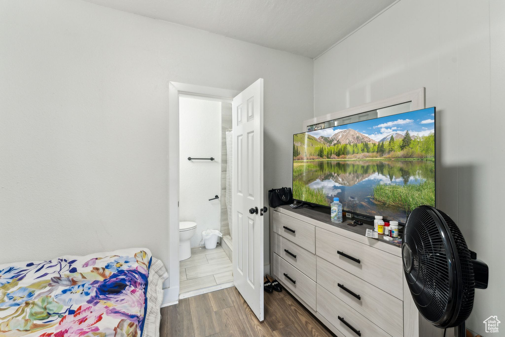 Bedroom featuring dark wood finished floors and connected bathroom