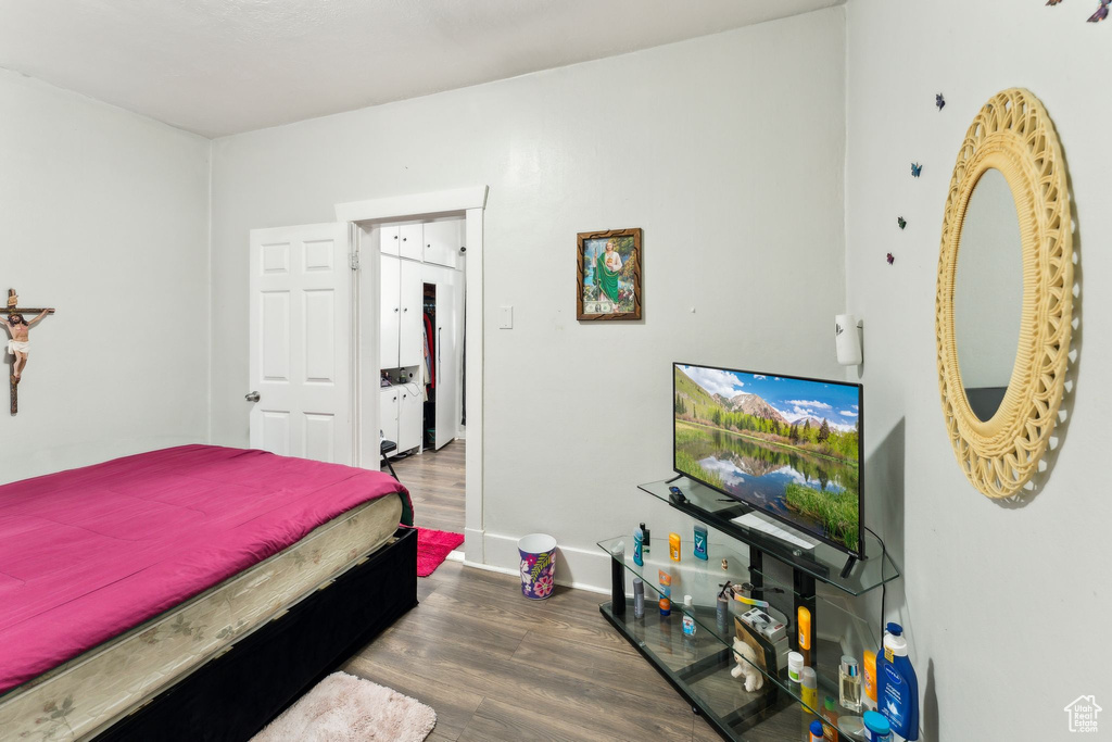 Bedroom with wood finished floors and baseboards