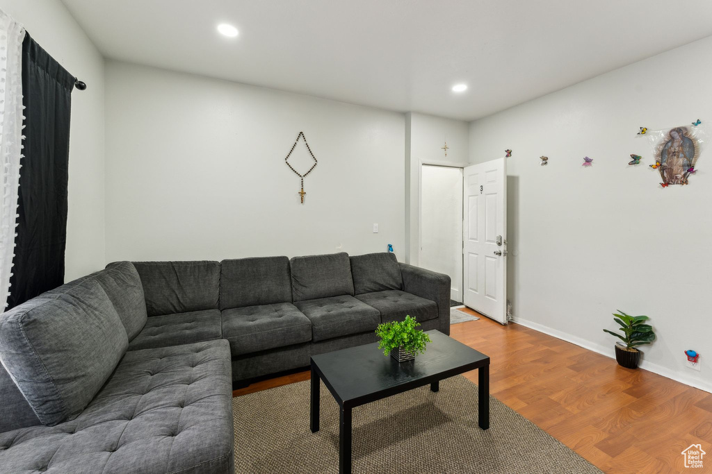 Living area with wood finished floors, recessed lighting, and baseboards