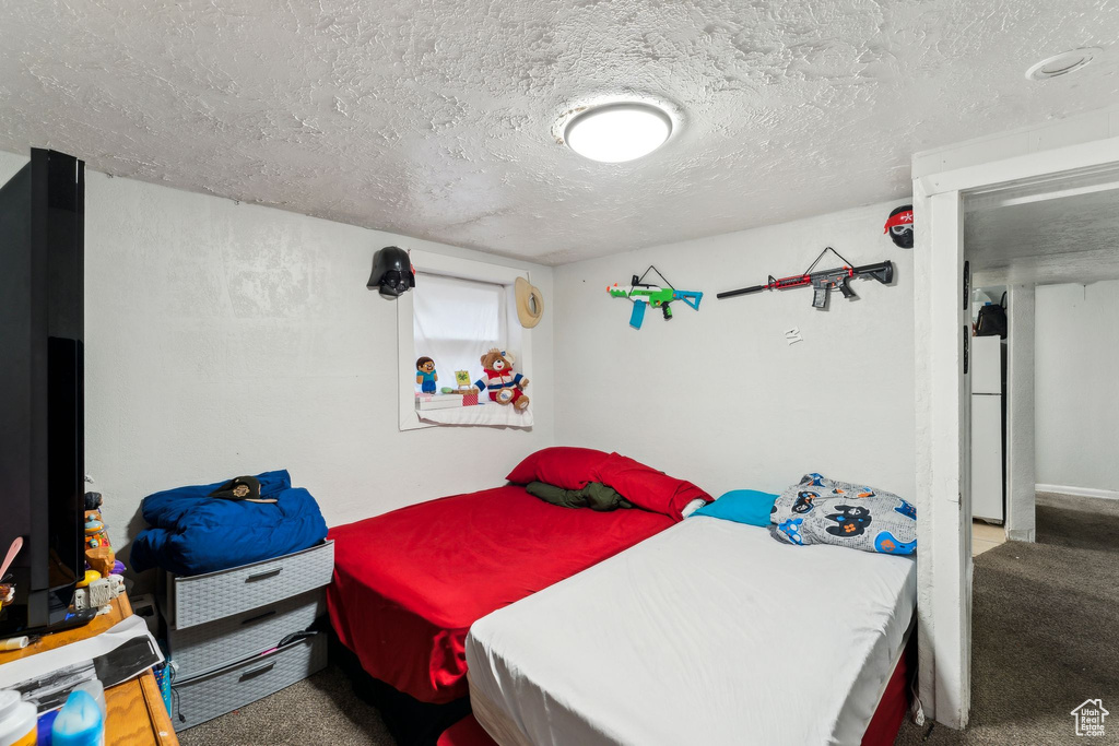 Bedroom featuring a textured ceiling and carpet floors