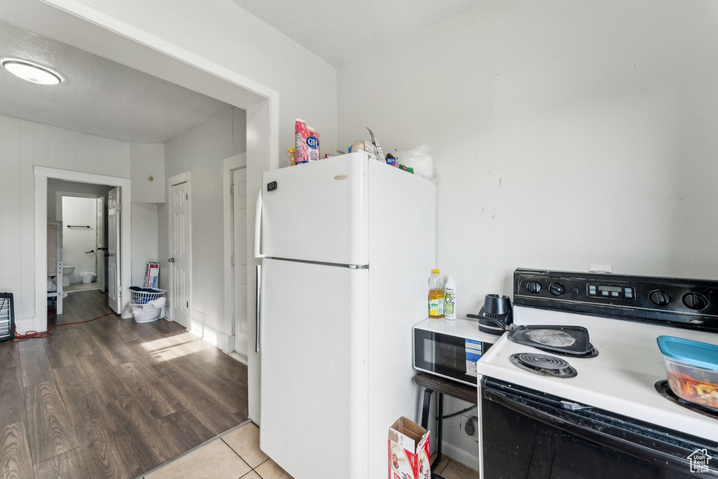 Kitchen featuring electric stove, freestanding refrigerator, light countertops, and tile patterned flooring