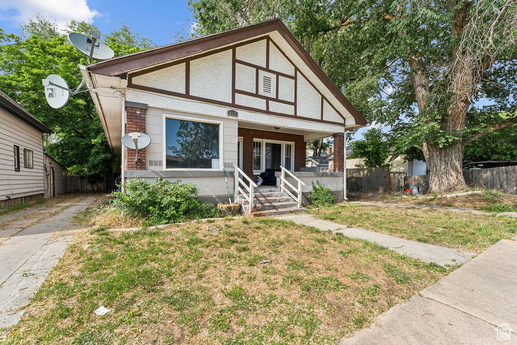 View of front of property featuring brick siding, covered porch, and driveway