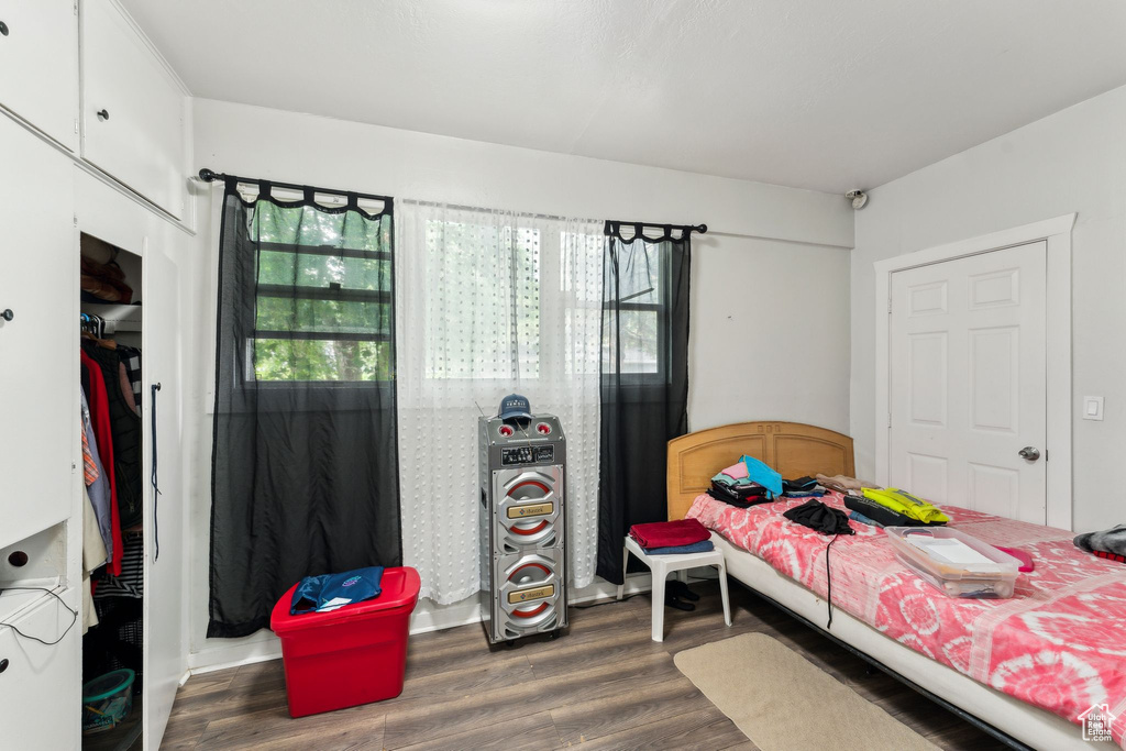 Bedroom featuring multiple windows and dark wood-type flooring