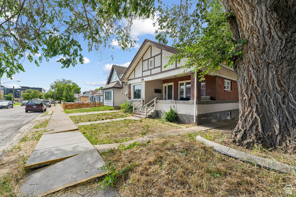 View of front of house with brick siding and covered porch