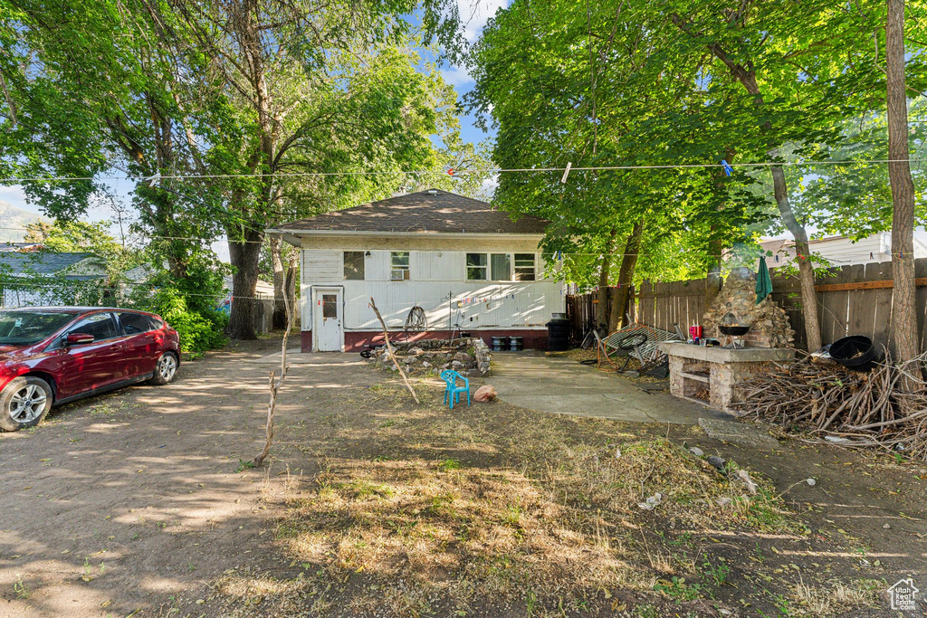 Back of house featuring a shingled roof