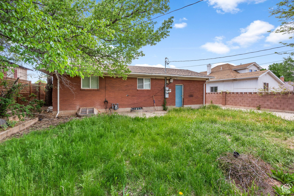 Rear view of house featuring fence and brick siding