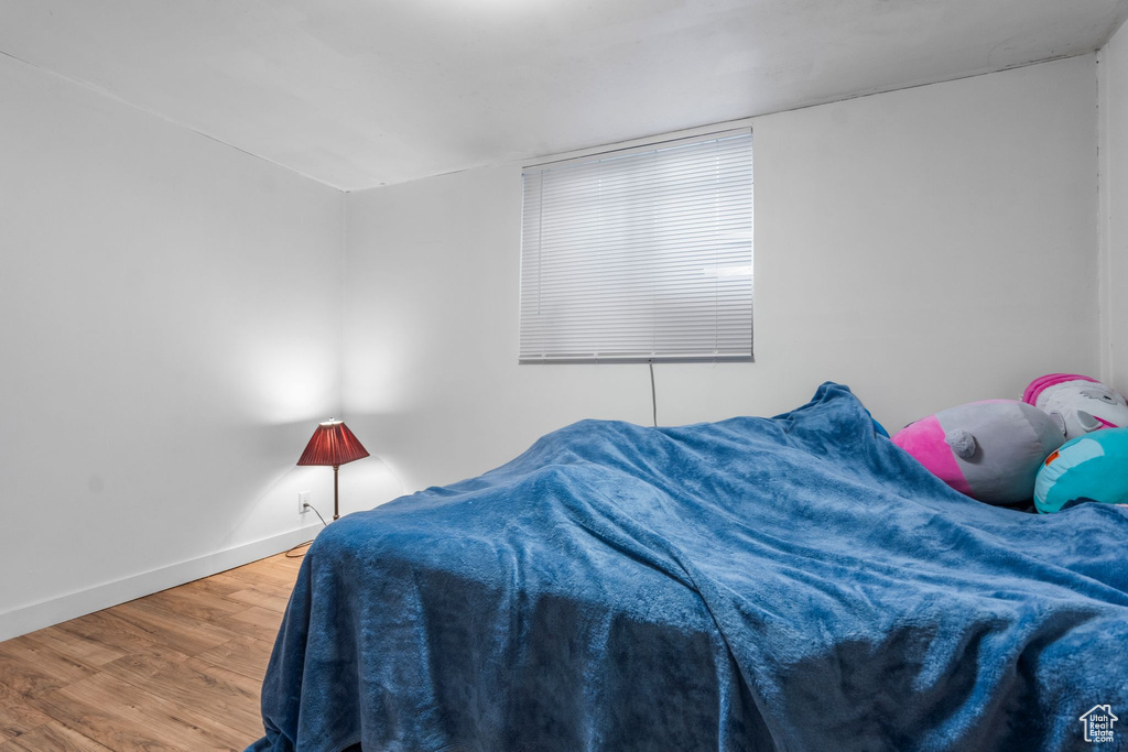 Bedroom with wood finished floors and baseboards