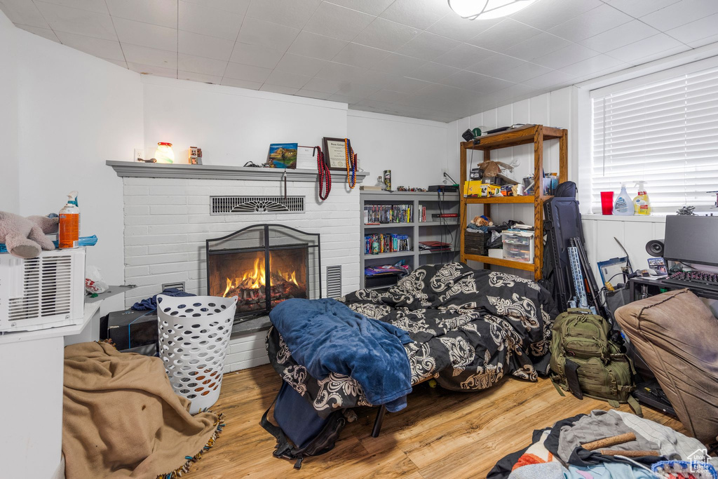 Bedroom with wood finished floors and a fireplace
