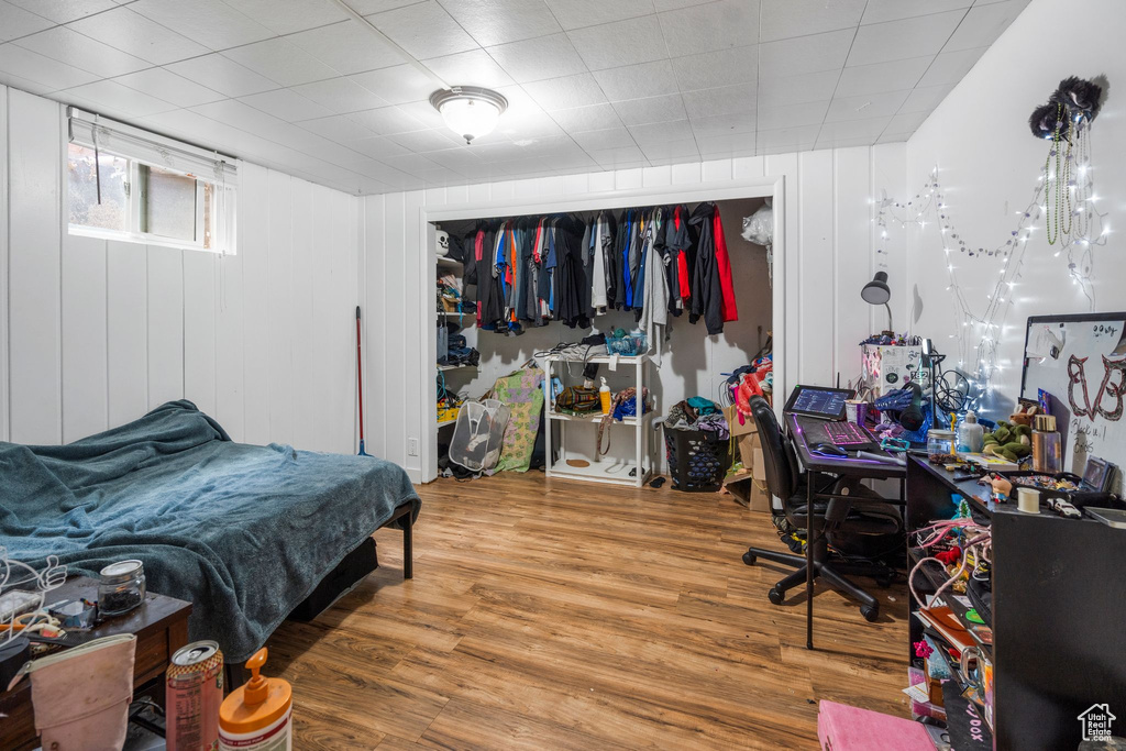 Bedroom with wood finished floors and a closet