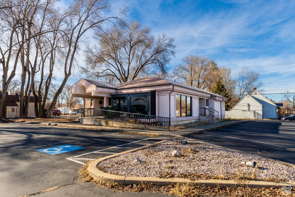 View of front of house with covered porch and uncovered parking