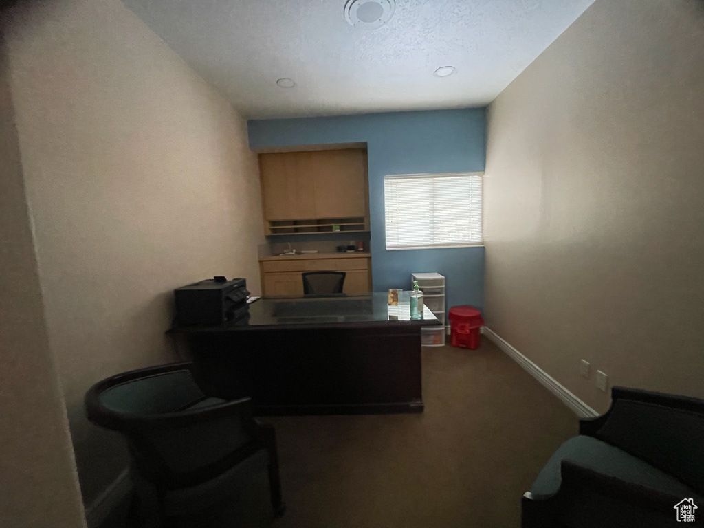 Carpeted office space featuring baseboards