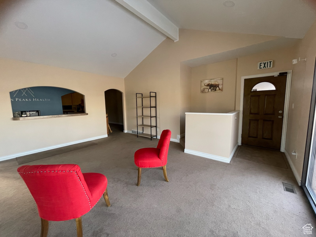 Foyer with arched walkways, carpet flooring, and baseboards
