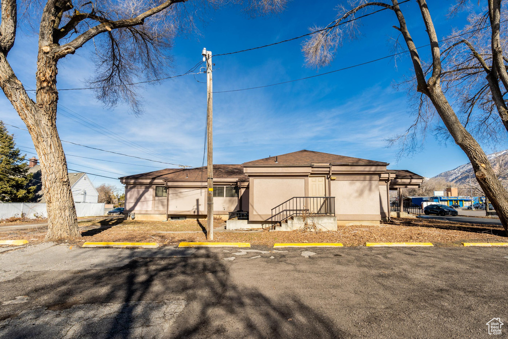 View of front of property with uncovered parking, stucco siding, and a mountain view