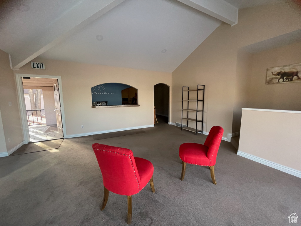 Sitting room featuring carpet flooring, arched walkways, and baseboards