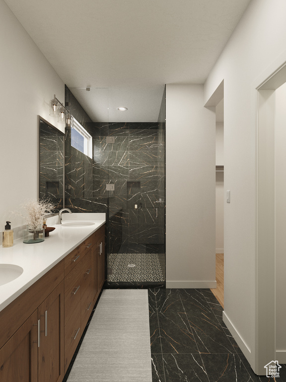 Full bathroom with a marble finish shower, double vanity, marble finish flooring, baseboards, and a spacious closet