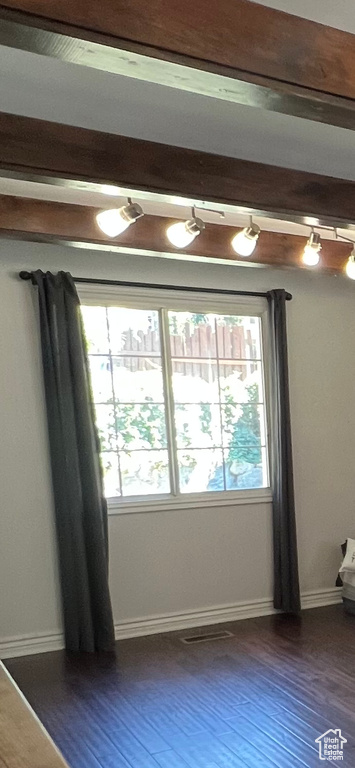 Unfurnished room with healthy amount of natural light, dark wood-type flooring, and baseboards