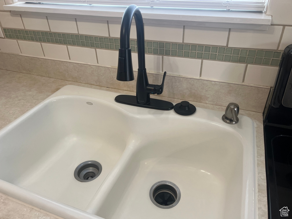 Kitchen view of a sink and light countertops