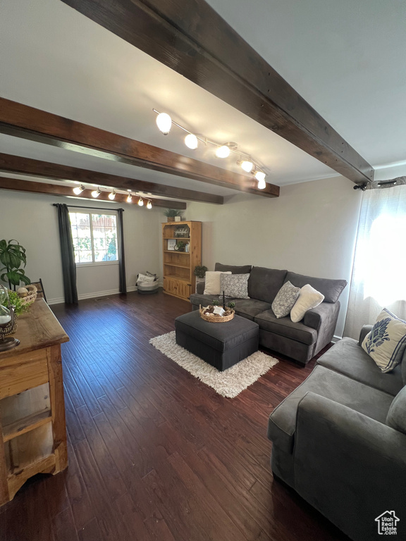 Living area with beam ceiling, dark wood-style floors, and baseboards