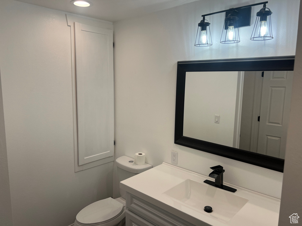 Bathroom with vanity, toilet, and recessed lighting