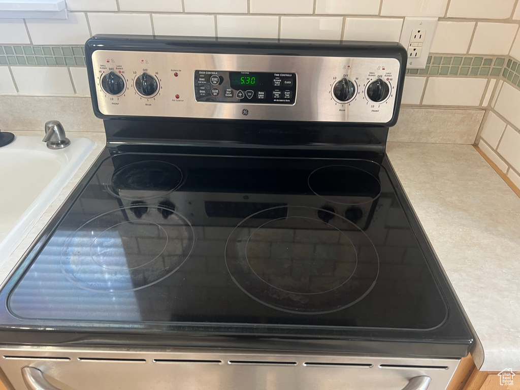 Kitchen view of stainless steel electric range and decorative backsplash