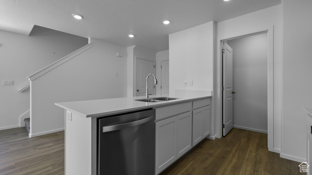 Kitchen with stainless steel dishwasher, a sink, dark wood-style flooring, a peninsula, and recessed lighting