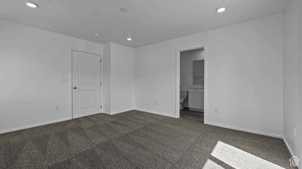 Unfurnished room with dark carpet, recessed lighting, and baseboards