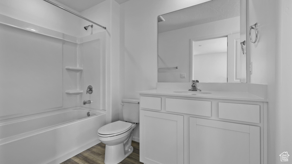 Full bath featuring toilet, vanity,  shower combination, and wood finished floors