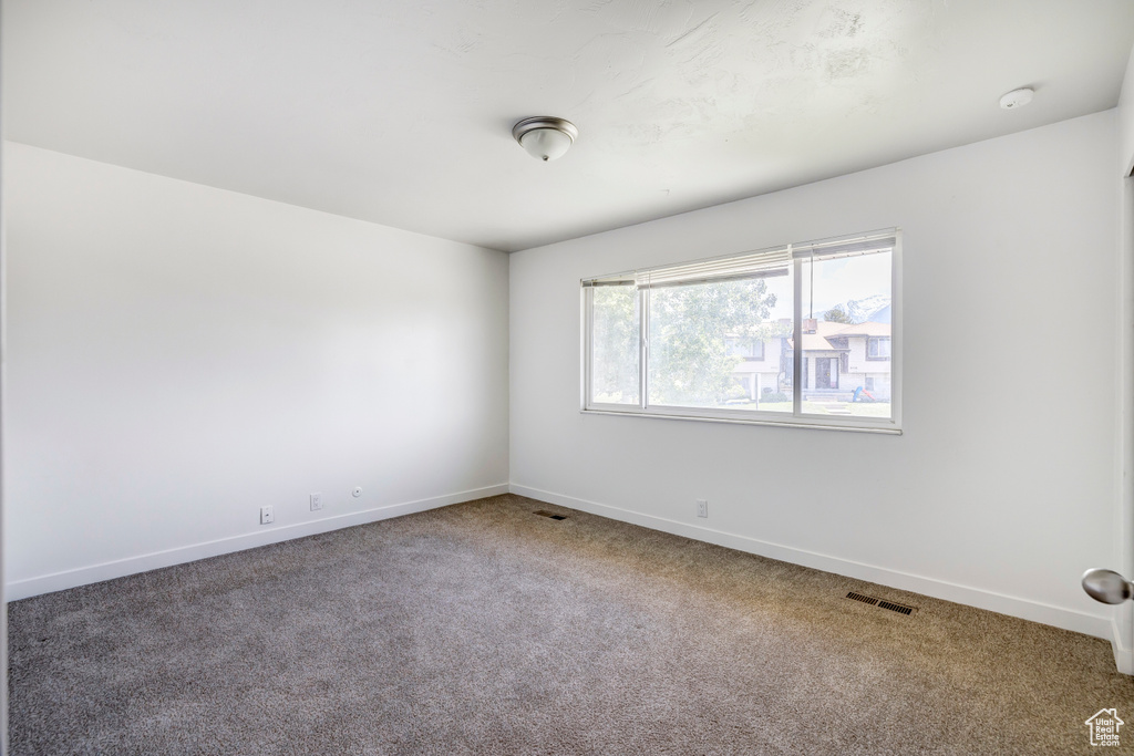 Empty room with carpet and baseboards