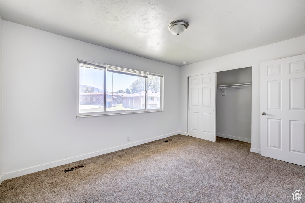 Unfurnished bedroom featuring carpet floors, a closet, and baseboards