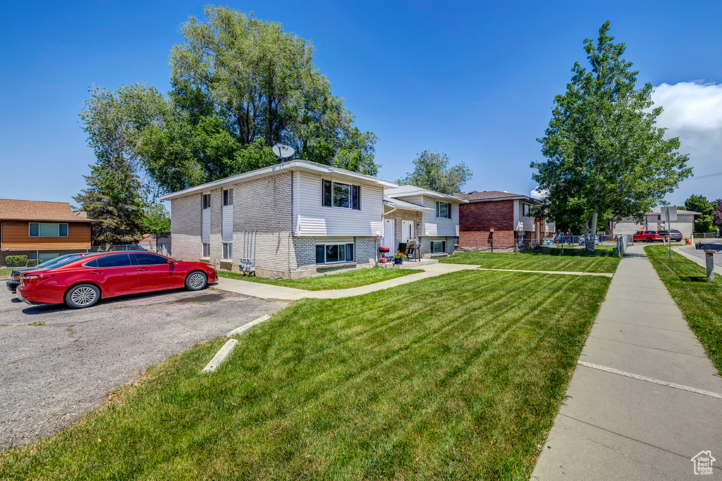 Bi-level home featuring brick siding and a front yard