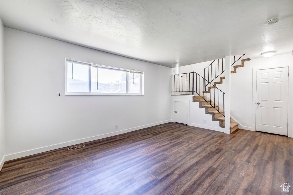Basement with dark wood finished floors, stairs, and baseboards