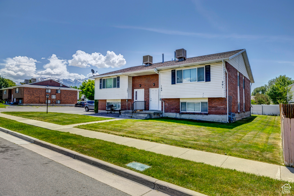 Bi-level home featuring brick siding and central AC