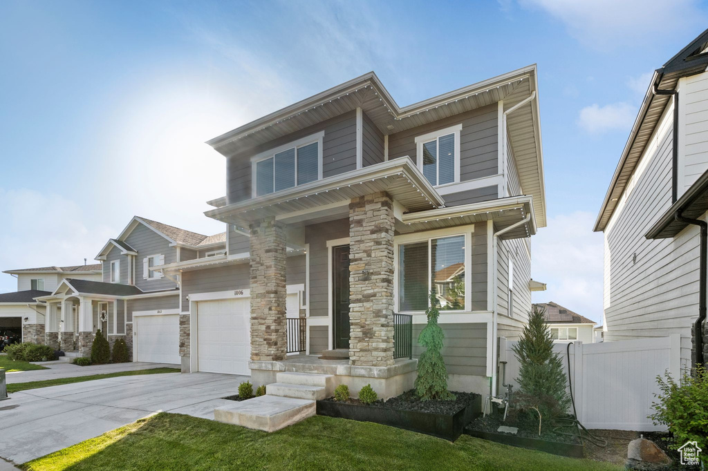 View of front of home with concrete driveway and a garage