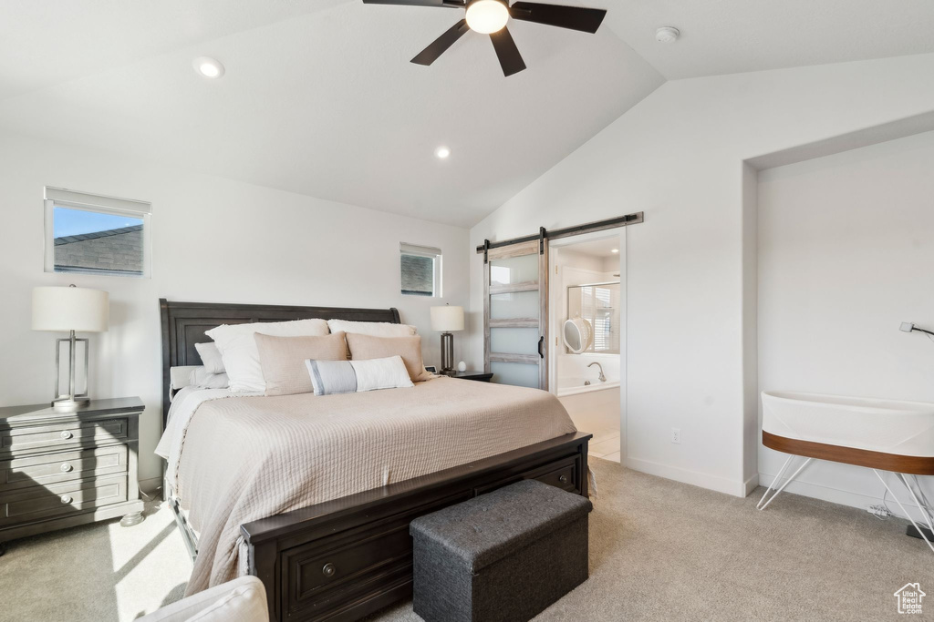 Bedroom with lofted ceiling, a barn door, light colored carpet, ceiling fan, and ensuite bath