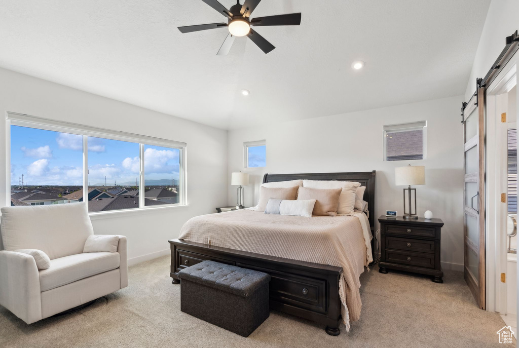 Bedroom featuring a barn door, light colored carpet, vaulted ceiling, recessed lighting, and baseboards