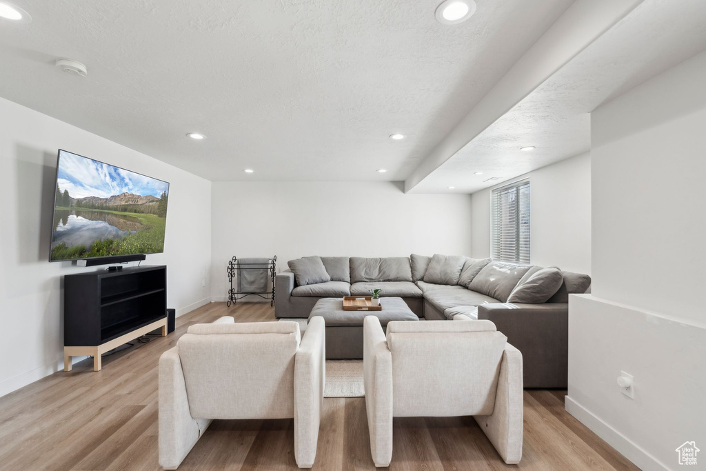 Living area featuring light wood-style flooring, baseboards, and recessed lighting