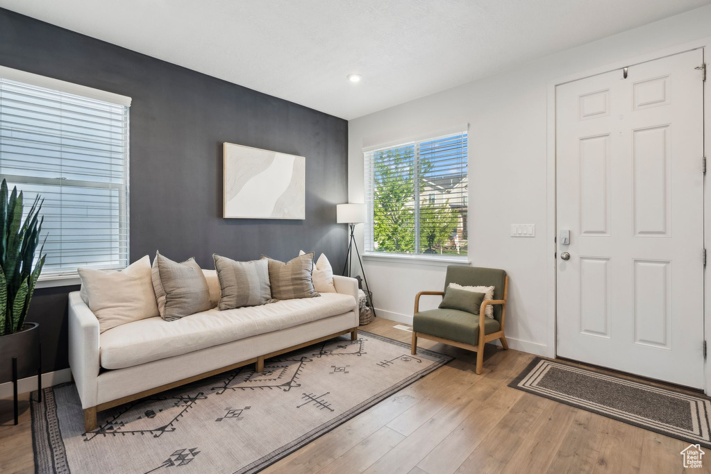 Living room with baseboards, wood finished floors, and recessed lighting