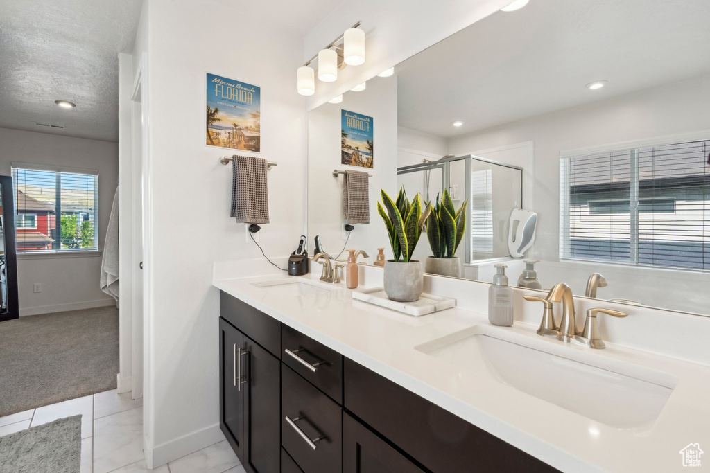 Full bath featuring double vanity, tile patterned floors, a stall shower, baseboards, and recessed lighting